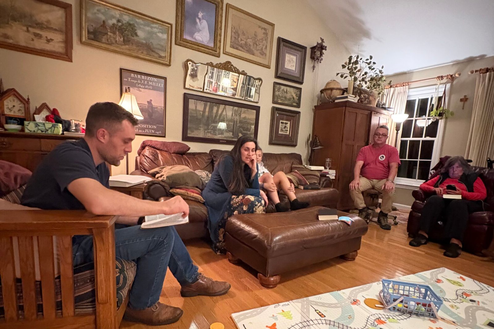 A Quidnessett Community Group gathered around an open Bible in a living room
